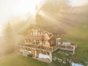 an overhead view of a wooden house with the sun shining at Chalet Etoile by Interhome in Nendaz