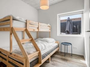 a bedroom with two bunk beds and a window at Holiday Home Bondi - 75m from the sea by Interhome in Knebel +17 photos
