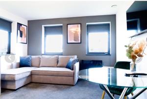 ein Wohnzimmer mit einer Couch und einem Glastisch in der Unterkunft The Aurelia Apartments VII - 1 Bed Apartment in Peterborough