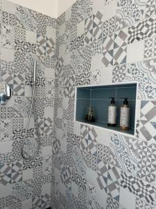 a bathroom with a shower and a tiled wall at L'obiettivo in Assemini