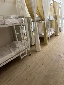 Habitación con 3 literas y suelo de madera. en Kareema's Hostel, en Chennai