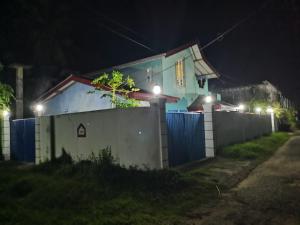 a house with a fence in front of it at night at Ceylon Traveller Homestay in Panadura