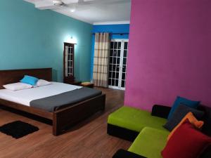 a bedroom with a bed and a couch at Ceylon Traveller Homestay in Panadura