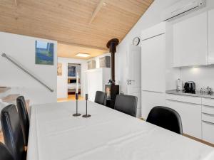 a dining room with a white table and chairs at Holiday Home Panu - 2-1km from the sea by Interhome in Bogø By