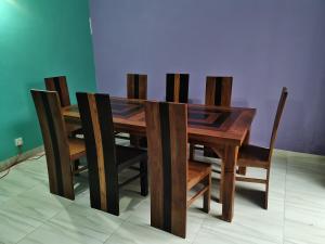 a wooden dining room table with four chairs around it at Ceylon Traveller Homestay in Panadura