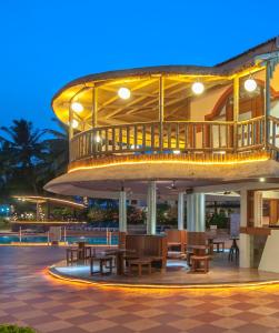 a building with tables and a balcony at night at Nanu Beach Resort & Spa in Betalbatim