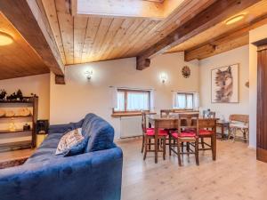 a living room with a blue couch and a table at Apartment Mansarda in Legno San Rocco by Interhome in Carisolo