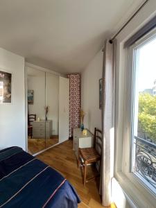 a bedroom with a bed and a large window at Charming 2 room appartement in Paris
