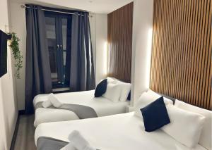 a hotel room with two beds and a couch at Amsterdam Hotel in London
