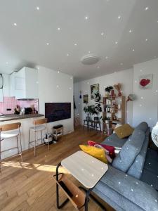 a living room with a blue couch and a kitchen at Charming 2 room appartement in Paris +9 photos