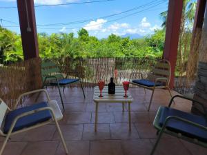 a patio with chairs and a table with wine glasses on it at studio Caraïbes in Les Trois-Îlets +1 photo