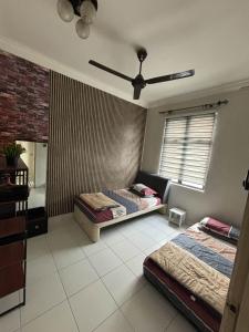 a bedroom with two beds and a ceiling fan at SBFAM HOMESTAY SHAH ALAM SEKSYEN 7 - NEAR i-CITY AND UITM in Shah Alam +8 photos