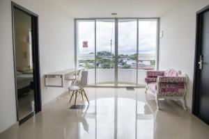 ein Wohnzimmer mit Tisch und Stühlen und einem Fenster in der Unterkunft Hotel Confort Ariari in Granada + 30 Fotos
