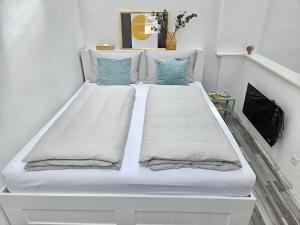 1 cama blanca grande en una habitación blanca en Lendhäuschen, en Klagenfurt