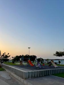 een speeltuin met glijbanen en speeltoestellen in een park bij Sultan Beach House in Muscat +33 foto's