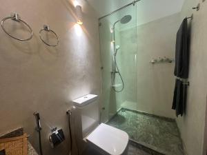 a bathroom with a toilet and a glass shower at Niyagama House in Galle