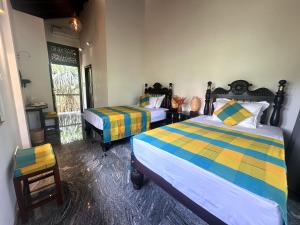 a bedroom with two beds and a window at Niyagama House in Galle +74 photos