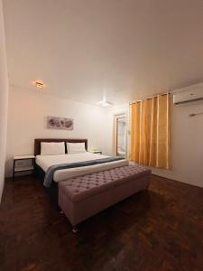 a bedroom with a bed and a bench in it at Clark stay in Fort Stotsenburg +42 photos