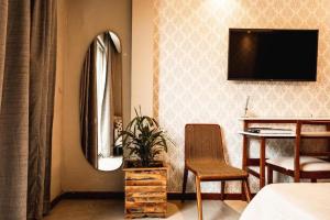 een slaapkamer met een tv en een tafel en een stoel bij Casanova Residence - Barra da Tijuca na Ilha da Gigoia in Rio de Janeiro