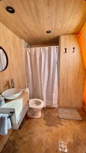 a bathroom with a toilet and a sink at El Nido Domos Potrerillos in Potrerillos