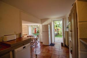 a kitchen with a refrigerator and a table and chairs at annexe du Mesnil in Le Tourne
