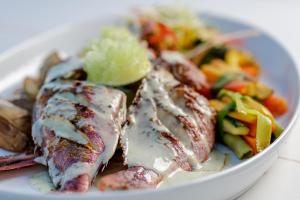 a plate of food with chicken and vegetables on a table at Royal Villa Fulidhoo in Fulidhoo