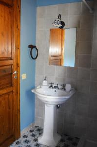 a bathroom with a white sink and a mirror at Agriturismo Pattina in Pettineo