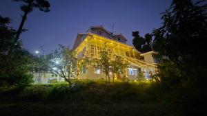 een groot geel gebouw met kerstverlichting bij The City Escape Farmstay in Shimla +24 foto's