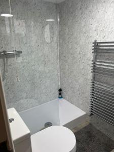 a bathroom with a white tub and a toilet at Llangollen - House - Sleeps 7 - Garden in Glyn-Ceiriog