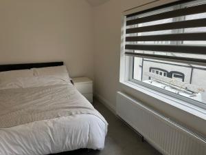 a bedroom with a bed and a window at Llangollen - House - Sleeps 7 - Garden in Glyn-Ceiriog