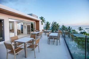 a patio with tables and chairs on a balcony at Royal Villa Fulidhoo in Fulidhoo