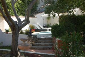 a garden with a bench and stairs next to a tree at Villa Nara in La Bouilladisse