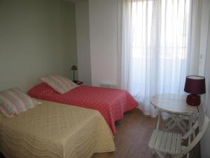 une chambre avec un lit, une table et une fenêtre dans l'établissement Résidence Beauséjour, à Carantec