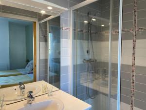 une salle de bains avec douche, lavabo et miroir dans l'établissement Résidence Beauséjour, à Carantec 22 autres photos