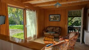 - une véranda avec 2 chaises et une table dans l'établissement Eco-friendly chalet with private hot tub, Vosges mountain, à Laveline-du-Houx