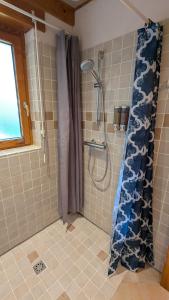 La salle de bains est pourvue d'une douche avec rideau de douche. dans l'établissement Eco-friendly chalet with private hot tub, Vosges mountain, à Laveline-du-Houx