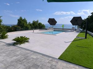 a patio with a swimming pool and grass at Lunisa VS1 Apartment in Kostrena