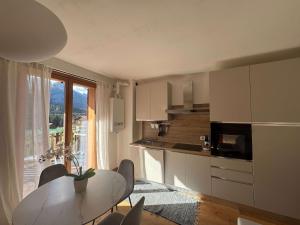 a kitchen with a table and chairs and a window at Siera Loft 1 - Panorama a 3 Minuti dalle Piste in Ecche
