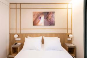 a bedroom with a bed with white sheets and two tables at Silken Apartamentos Goya in Oviedo