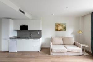 オビエドにあるSilken Apartamentos Goyaの白いリビングルーム(ソファ付)、キッチンが備わります。