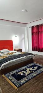 a bedroom with a bed and a rug on the floor at Hotel Thangshing In in Lachung