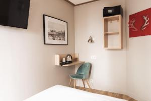 a room with a bed and a green chair at Hôtel Eiffel Segur in Paris