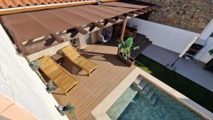 an overhead view of a deck with two chairs and a pool at Casa da Capela - CASAS BEMHAJA in São Miguel de Acha
