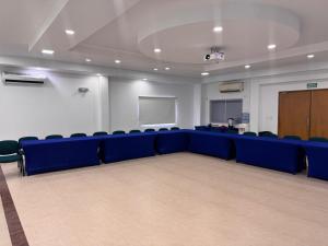 einen Konferenzraum mit blauen Stühlen und einem Podium in der Unterkunft Hotel Confort Ariari in Granada