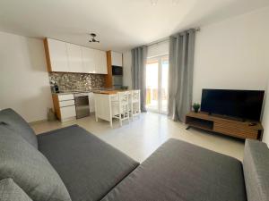 a living room with a couch and a kitchen at Casa da Laje - CASAS BEMHAJA in São Miguel de Acha