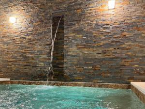 a water fountain in a brick wall at Casa da Laje - CASAS BEMHAJA in São Miguel de Acha
