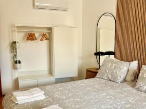 a bedroom with a bed with a large mirror at Casa da Laje - CASAS BEMHAJA in São Miguel de Acha +34 photos