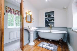 une salle de bain avec une baignoire blanche et un lavabo dans l'établissement Apple House by Staycay, à Nether Alderley