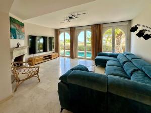 una gran sala de estar con un gran sofá azul en Asia Gardens Villa with private pool in Benidorm, en Cala de Finestrat