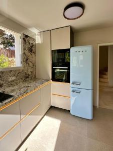 Una cocina con un refrigerador blanco y una ventana. en Asia Gardens Villa with private pool in Benidorm, en Cala de Finestrat